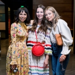 three women hug at public event