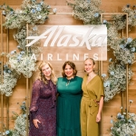 women gather under branded sign at formal gathering