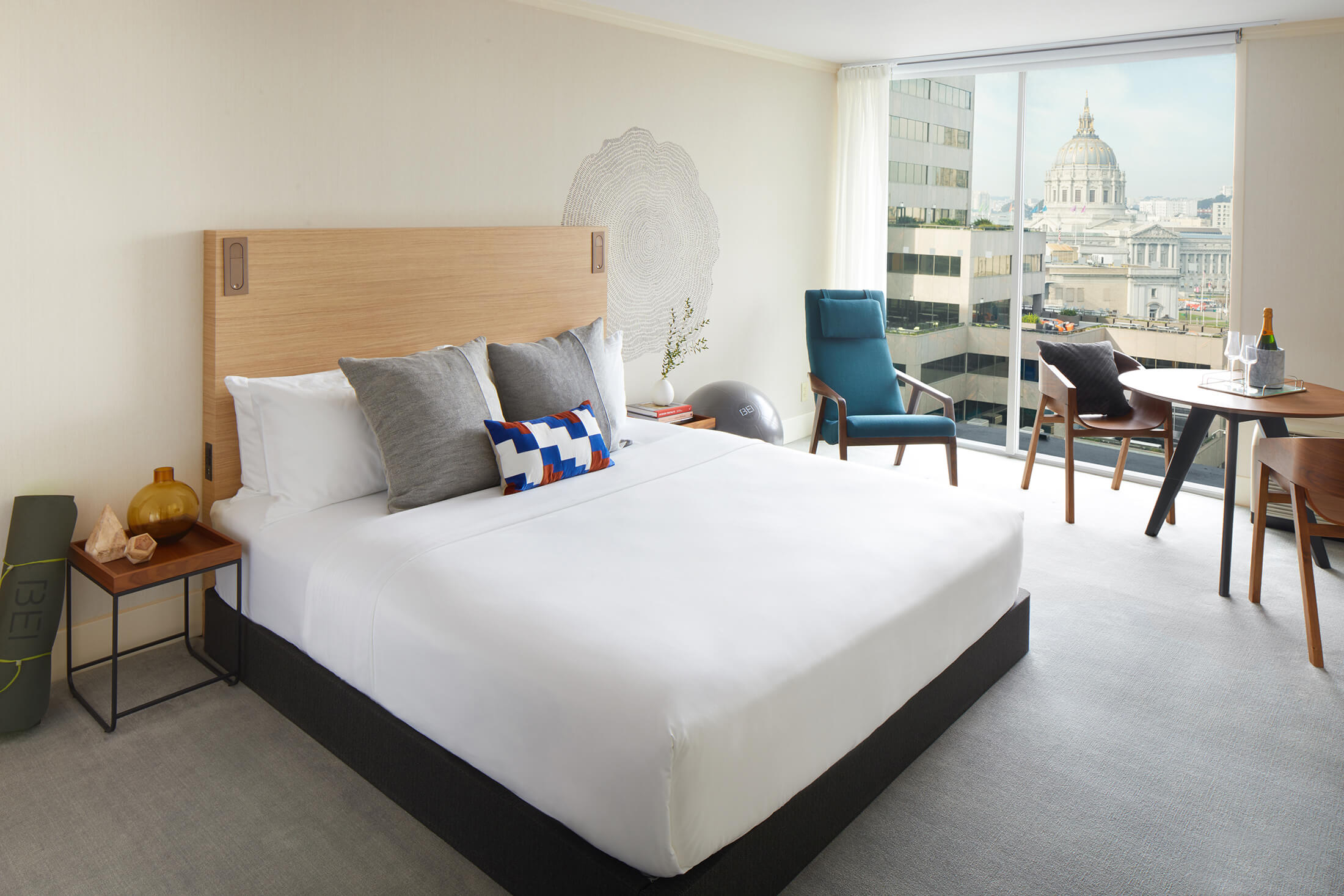 hotel room with large white bed and seating area by window