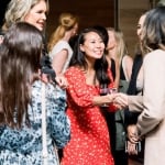 group of women talk and shake hands