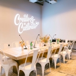 board room table with white metal chairs and artful place settings