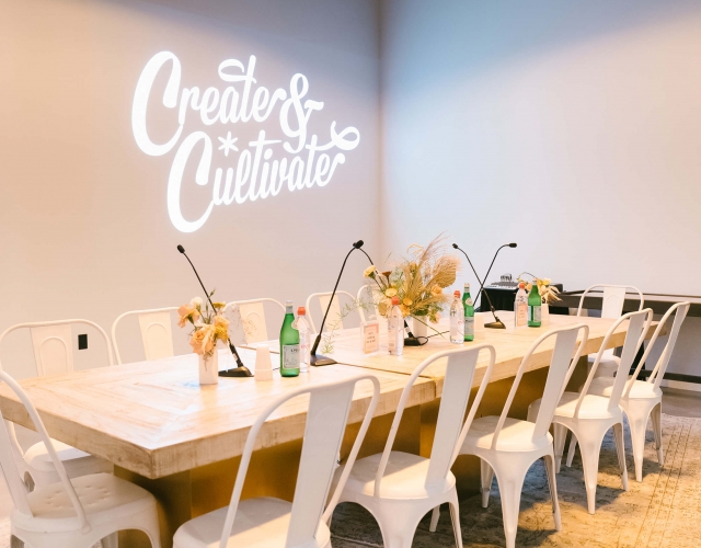 board room table with white metal chairs and artful place settings