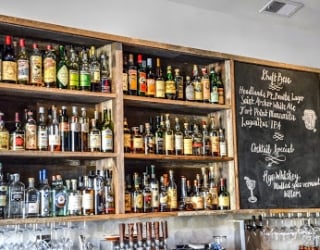 bar with three shelves full of liquor bottles