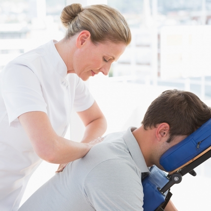 Man getting massage on chair by professional
