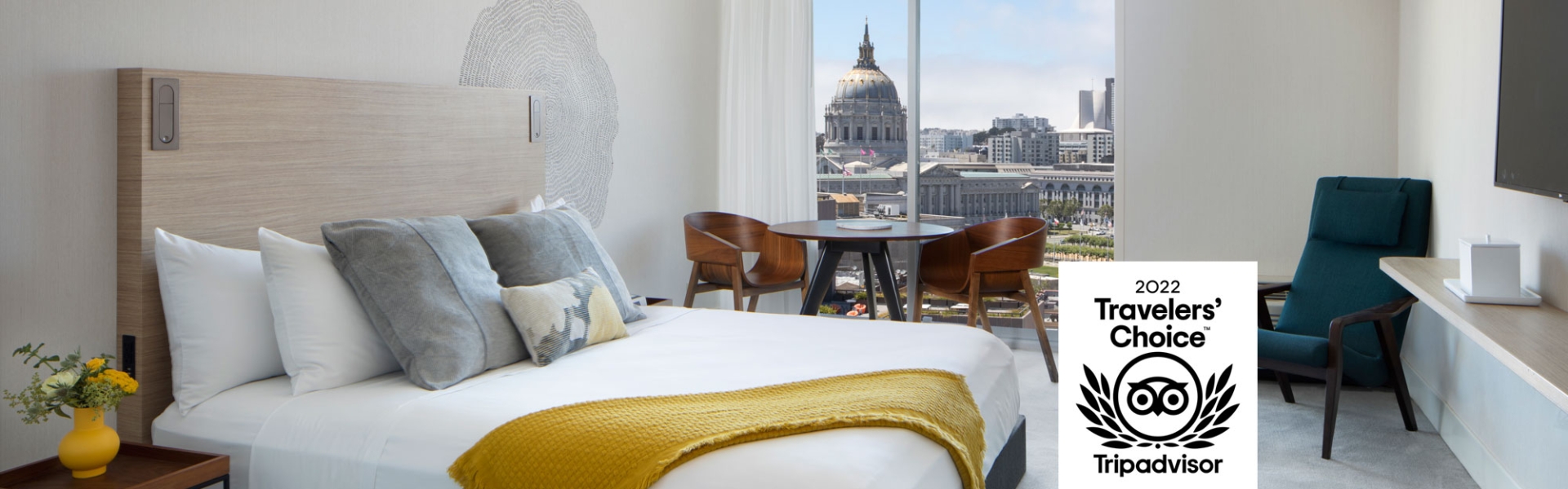 guest room with one king bed and view of downtown San Fran with TripAdvisor 2022 Travelers Choice Logo